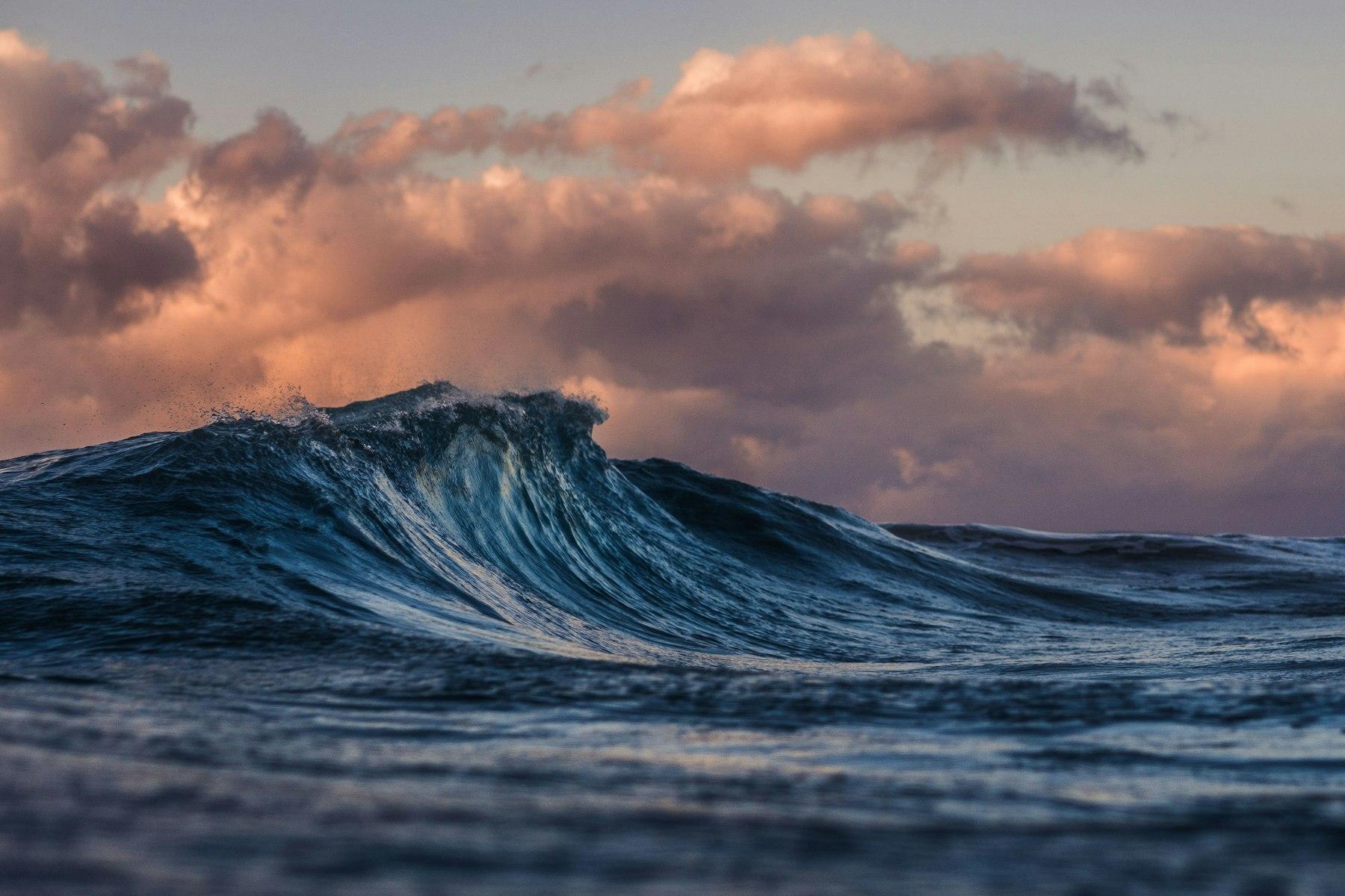 Ocean wave under an evening sky